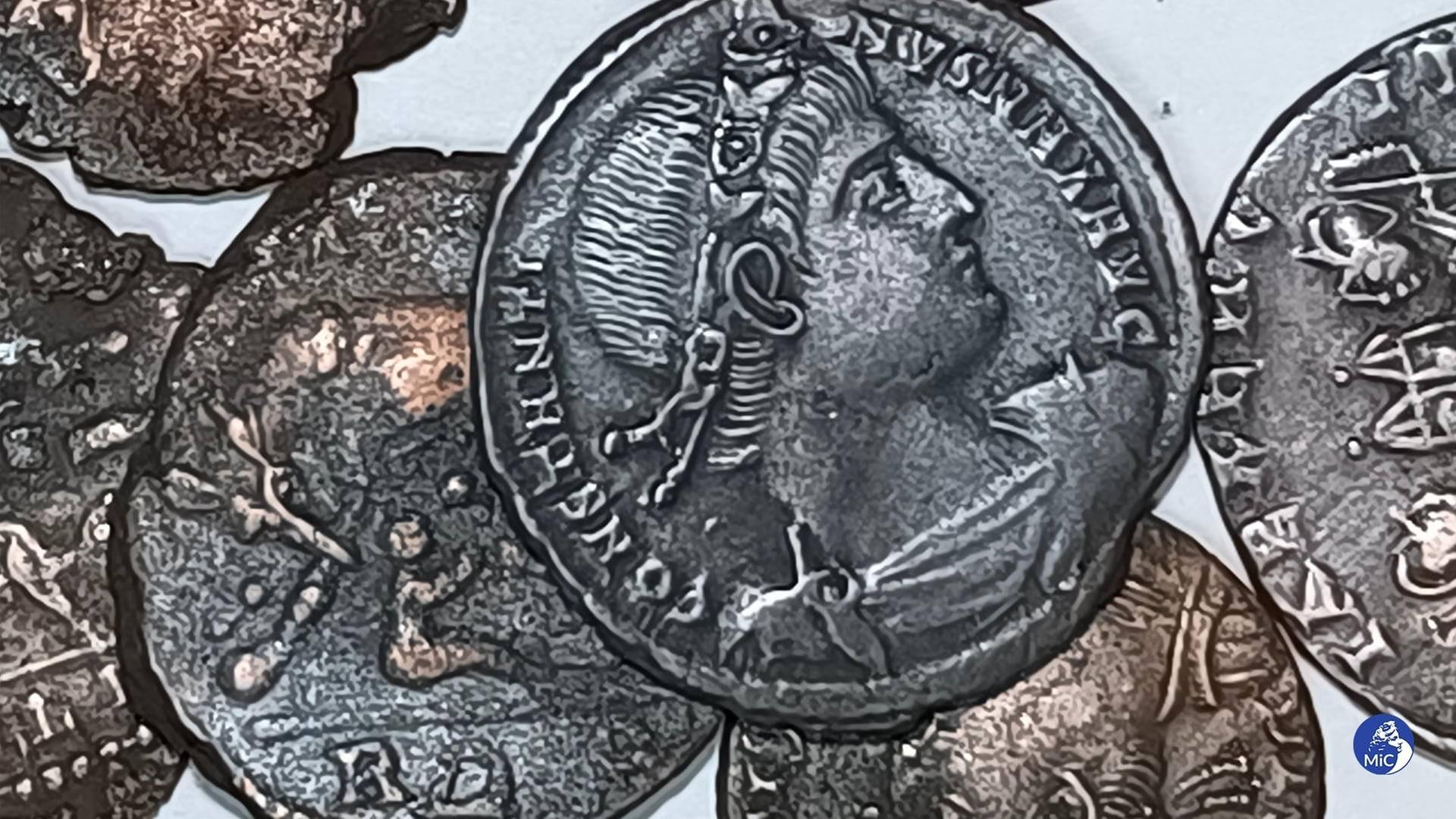 Mehrere silberne Münzen liegen nebeneinander. Man sieht die Schrift-Prägung und die Abbildung eines Kopfes.