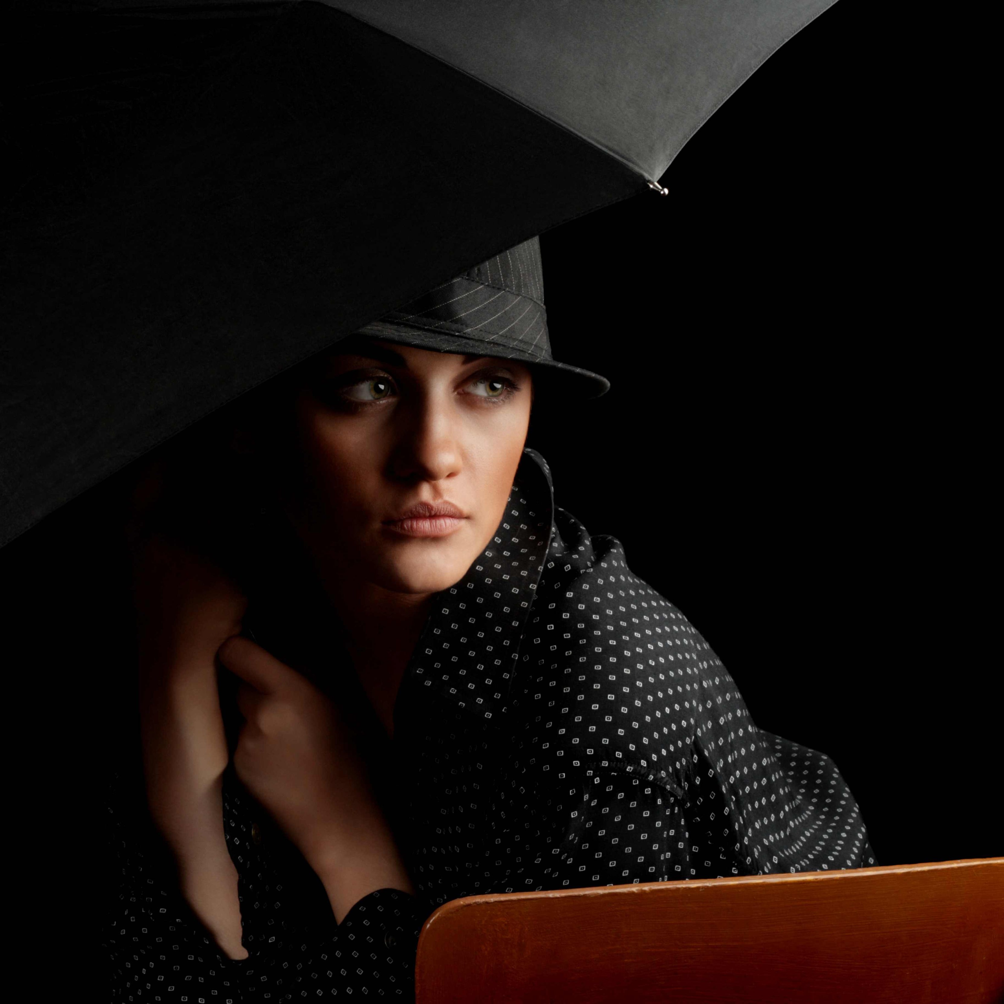 Bild in Schwarztönen: Elegante Frau mit Hut und Schirm im Stil der 1930er Jahre in Chicago, mysteriöser Blick.