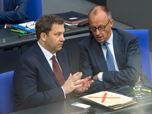 Bundesfinanzminister Lars Klingbeil (links) und Bundeskanzler Friedrich Merz /CDU) sitzen am 11.06.2026  im  Bundestag. Merz erzählt Klingbeil offenbar etwas. Beide wirken angespannt.