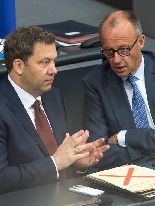 Bundesfinanzminister Lars Klingbeil (links) und Bundeskanzler Friedrich Merz /CDU) sitzen am 11.06.2026  im  Bundestag. Merz erzählt Klingbeil offenbar etwas. Beide wirken angespannt.