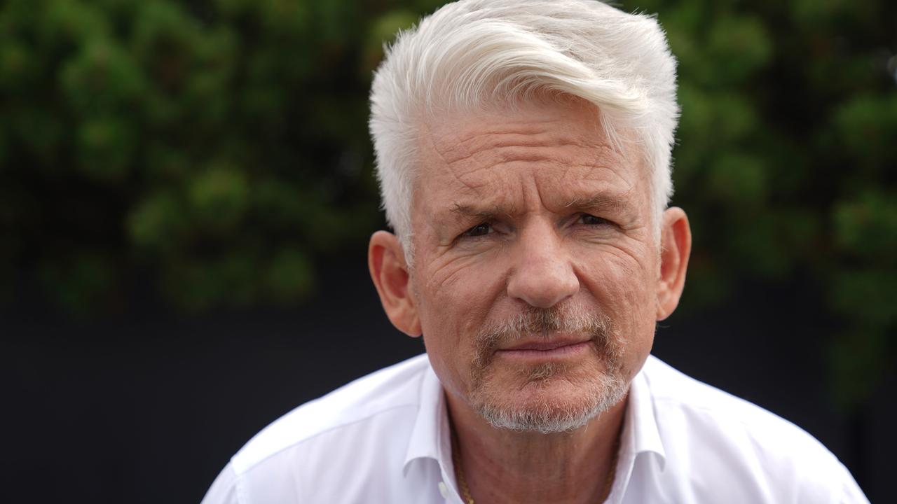 Porträt des Autors Heinz Strunk. Ein Mann mit weißem Haar und weißem Hemd.