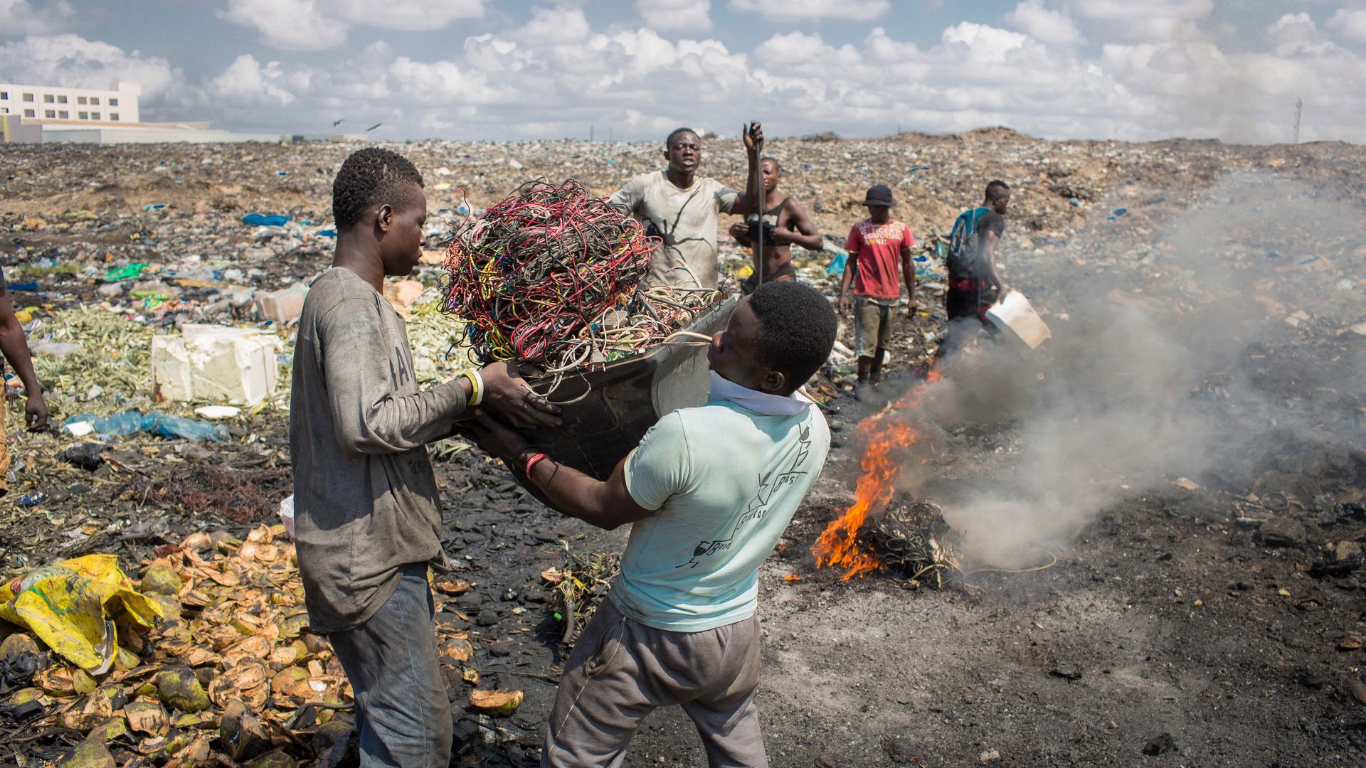 Junge afrikanische Männer verbrennen Elektroschrott auf der grössten Elektromülldeponie Afrikas in Agbogbloshie, einem Stadtteil von Ghanas Hauptstadt. Hier verbrennt man ausgediente Altgeräte, um an verwertbares Metall zu kommen. 