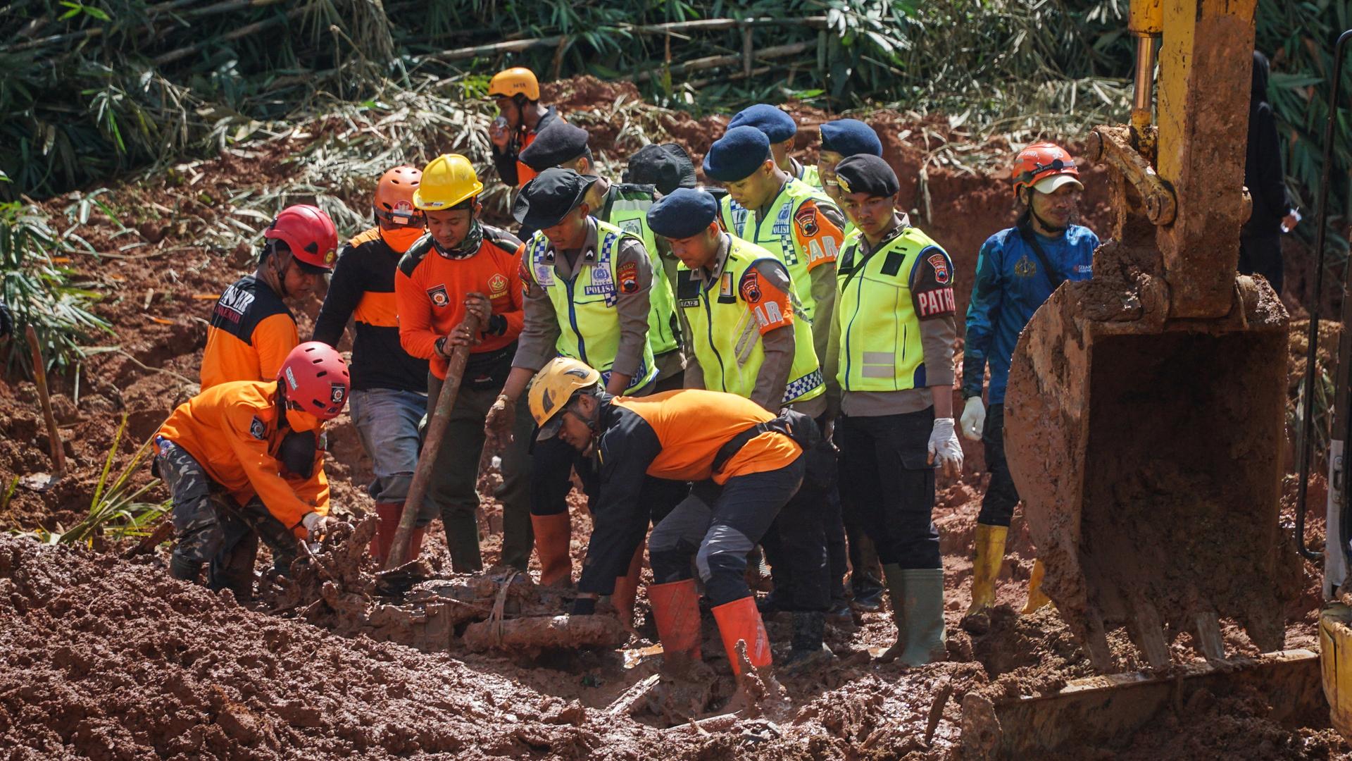 Helfer versuchen nach den Erdrutschen die Opfer zu bergen.
