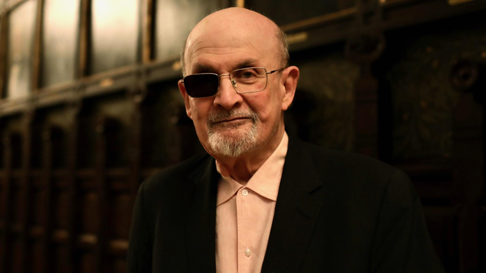 Der Schriftsteller Salman Rushdie lächelt verhalten in die Kamera
