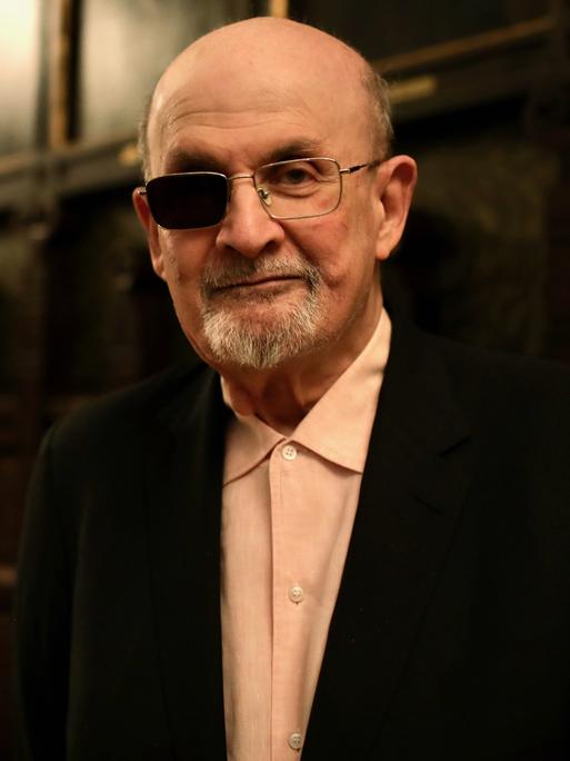 Der Schriftsteller Salman Rushdie lächelt verhalten in die Kamera