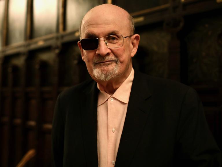 Der Schriftsteller Salman Rushdie lächelt verhalten in die Kamera