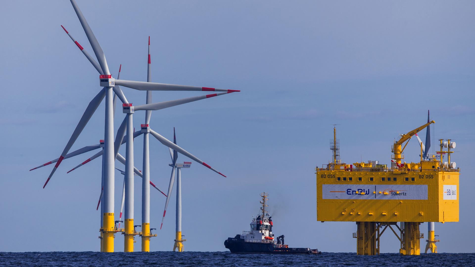 Zu sehen sind mehrere Windräder in der Ostsee, in der Mitte ein Schlepper, rechts eine Anlage zur Umwandlung von Strom. Zu sehen sind mehrere Windräder in der Ostsee, in der Mitte ein Schlepper, rechts eine Anlage zur Umwandlung von Strom.