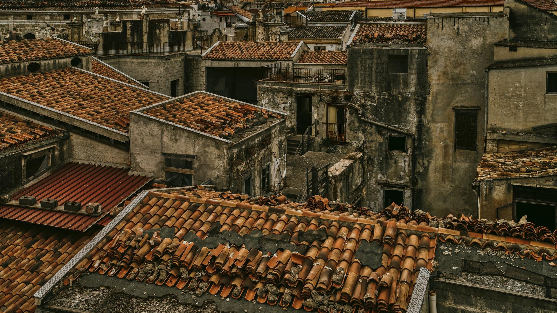 Ein Dorf mit heruntergekommenen Mauern und kaputten Ziegeldächern