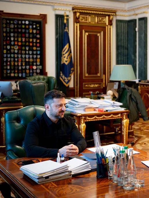 Selenskyj und Shmyal sitzen in einem Büro gemeinsam zu einer Besprechung am Schreibtisch.