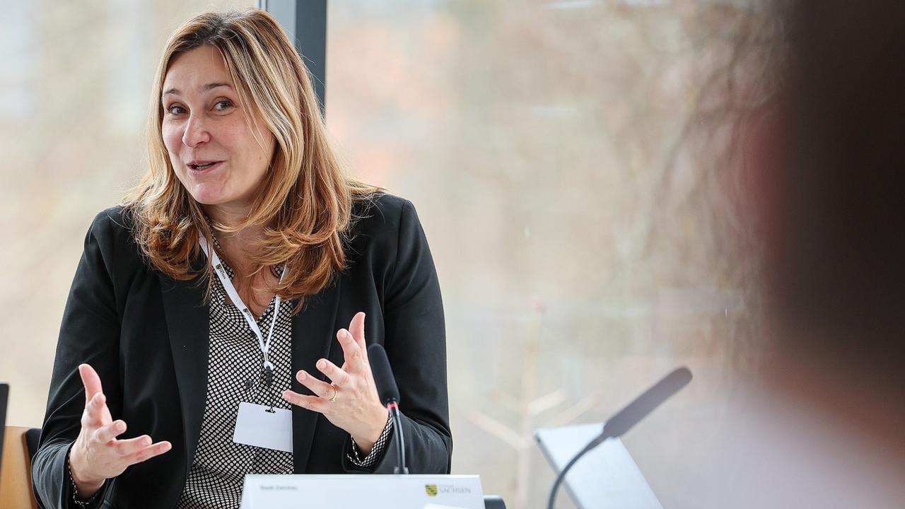 Constance Arndt, Oberbürgermeisterin von Zwickau. Sie sitzt gestikulierend an einem Tisch. 