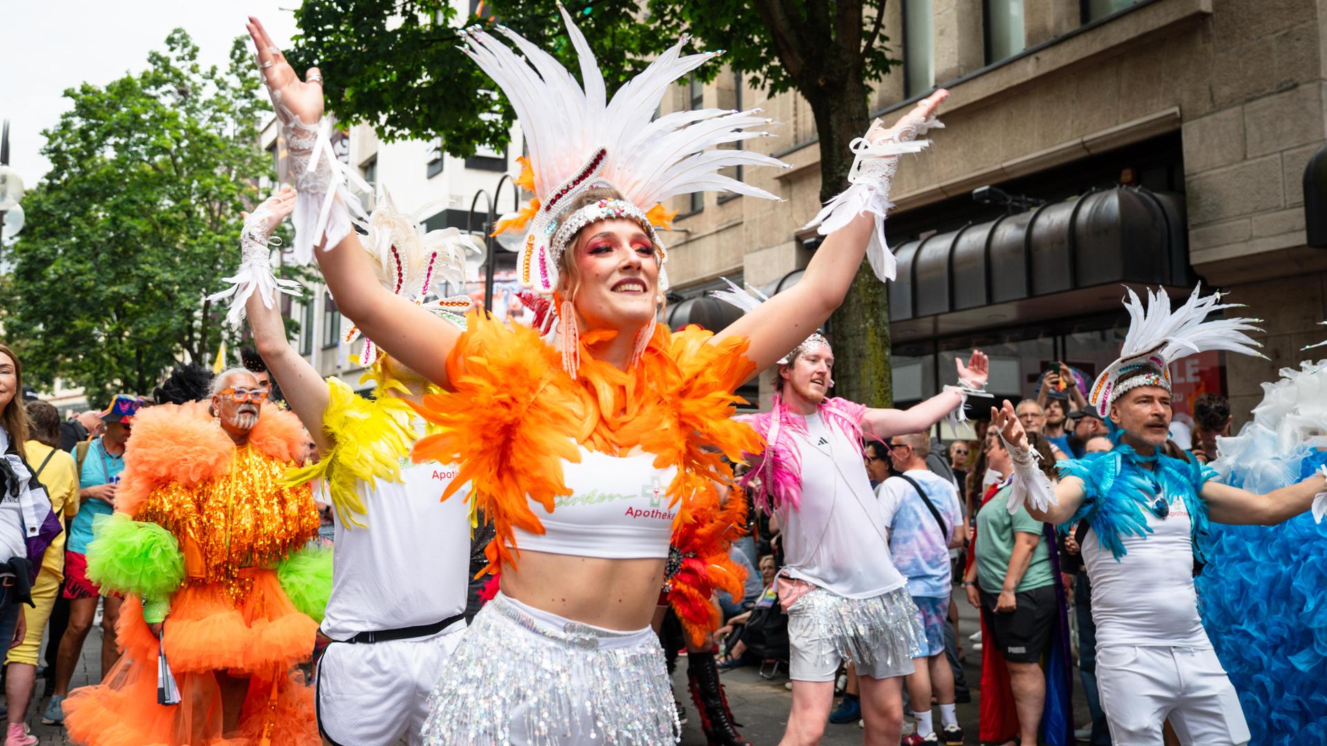 Bunt kostümierte Teilnehmer tanzen bei der CSD-Parade in Köln.