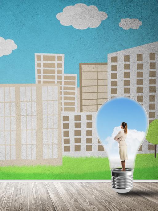In der Zeichnung steht eine Frau in hellem Business-Kostüm in einer Glühlampe und schaut auf eine Landschaft mit vielen Bürohäusern.