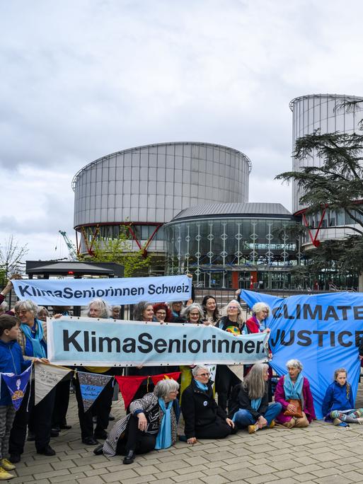Die Schweizer Klimaseniorinnen sitzen mit Plakaten vor dem Europäischen Gerichtshof für Menschenrechte 