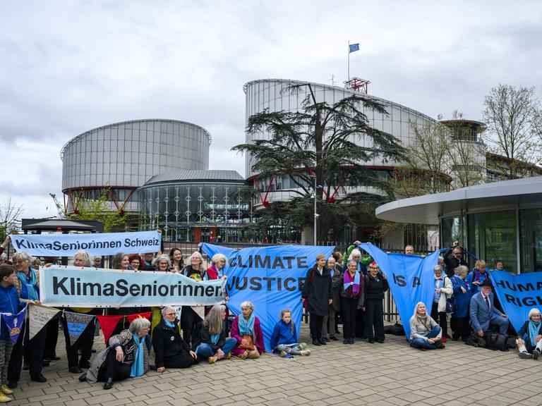 Die Schweizer Klimaseniorinnen sitzen mit Plakaten vor dem Europäischen Gerichtshof für Menschenrechte 