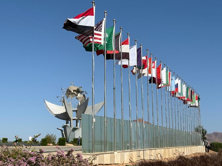 Die Flaggen der Staaten, die an der Unterzeichnung des Gaza-Abkommens teilnehmen, wehen im ägyptischen Küstenort Scharm el Scheich an einer Straße. 