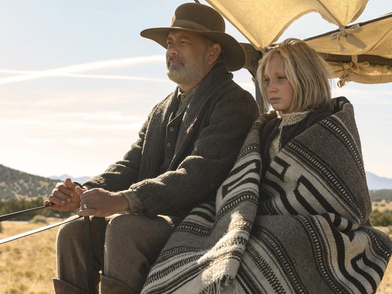 Tom Hanks und Helena Zengel fahren in dem Film "News of the World" in einem Planwagen. © Universal Pictures / Courtesy Everett Collection