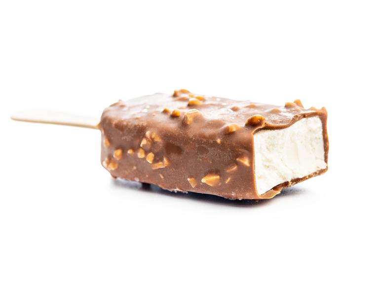 Eiscreme mit Schoko-Mandel-Umhüllung am Stiel, verführerisch vor weißem Hintergrund inszeniert: Am oberen Ende ist die Umhüllung bereits weg. 