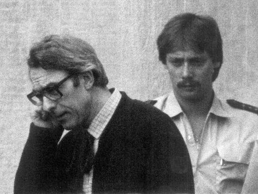 Der ehemalige Rechtsanwalt Manfred Roeder (l) wird am 28.6.1982 in Stuttgart-Stammheim zur Urteilsverkündung geführt: Er wurde als Rädelsführer der rechtsterroristischen "Deutschen Aktionsgruppen" zu 13 Jahren Haft verurteilt.