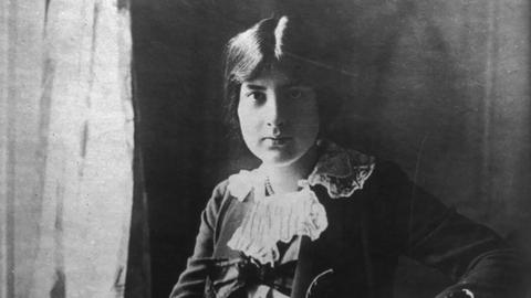 Lili Boulanger sitzt mit ernstem Gesichtsausdruck und hochgesteckten Haaren vor der Kamera.