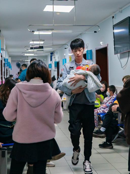 Eltern mit Kindern, die an Atemwegserkrankungen leiden, stehen am 23. November 2023 in einem Kinderkrankenhaus in Chongqing, China, Schlange.