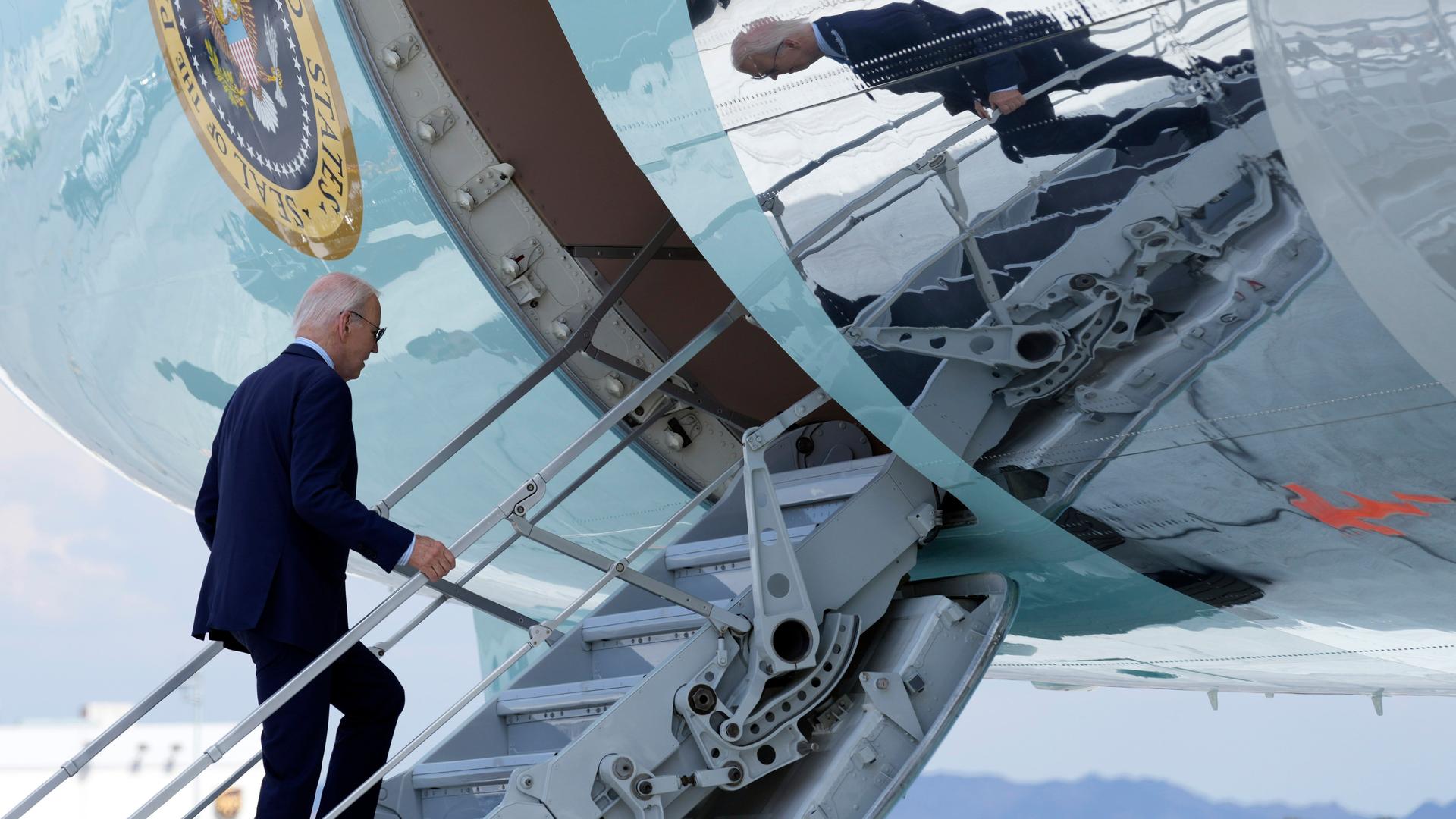 US-Präsident Joe Biden steigt über die Gangway in ein großes Flugzeug. Es ist die Präsidentenmaschine Air Force One.