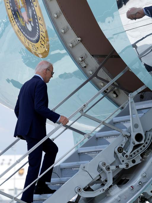 US-Präsident Joe Biden steigt über die Gangway in ein großes Flugzeug. Es ist die Präsidentenmaschine Air Force One.
