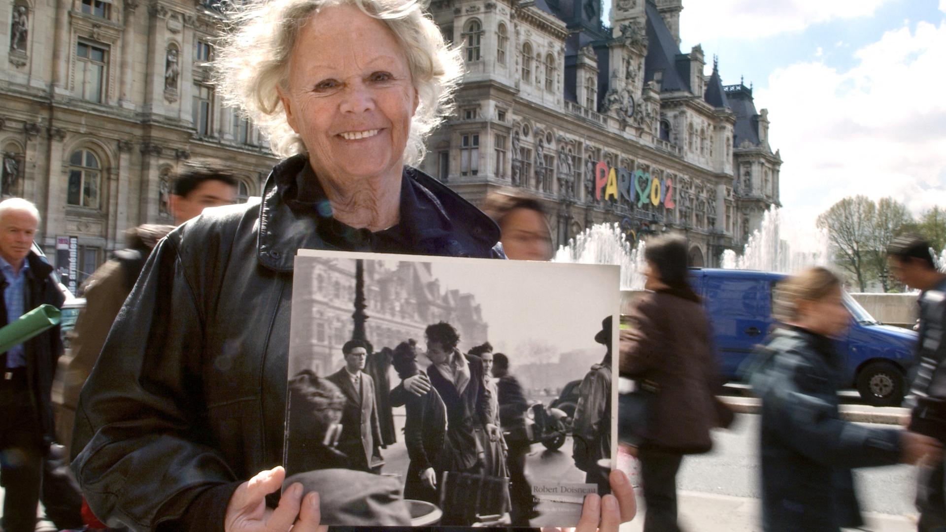 Françoise Bornet steht vor dem Rathaus und hält ihr Bild von 1950 in den Händen.
