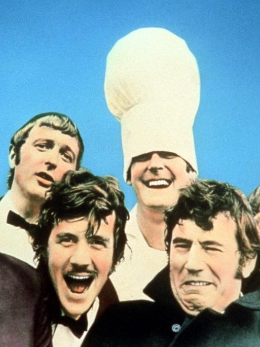 Die Komiker von Monty Python in exaltierten Kostümen und mit witzig verzogenen Fratzen