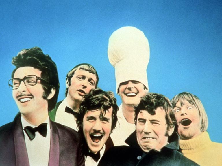 Die Komiker von Monty Python in exaltierten Kostümen und mit witzig verzogenen Fratzen