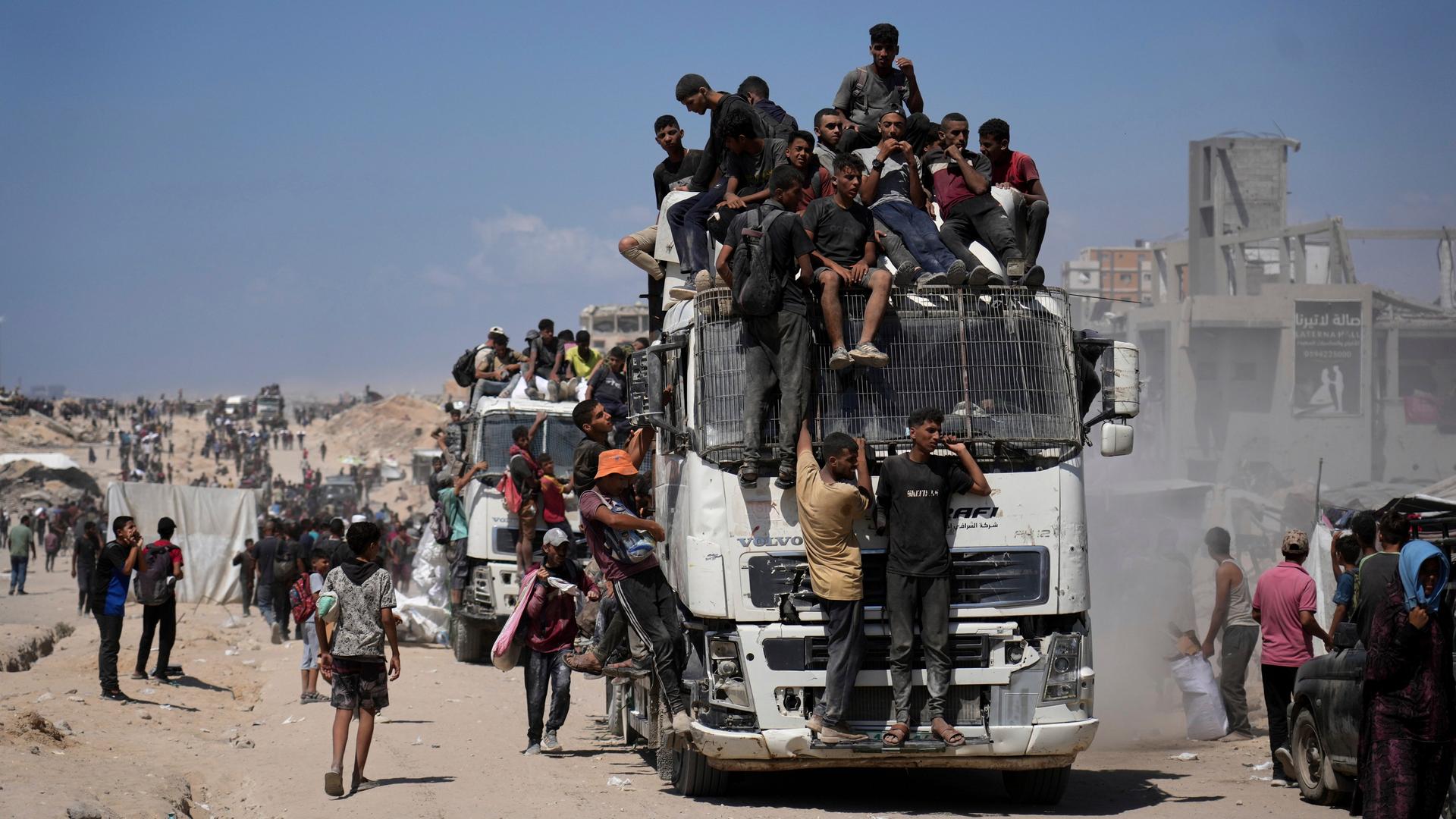 Menschen sitzen in Gaza auf einem Lkw, der Nahrungsmittel transportiert.
