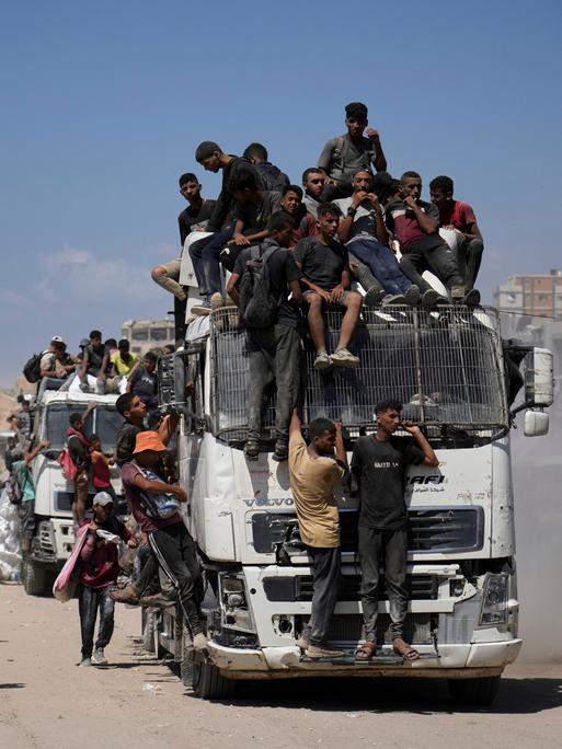 Menschen sitzen in Gaza auf einem Lkw, der Nahrungsmittel transportiert.