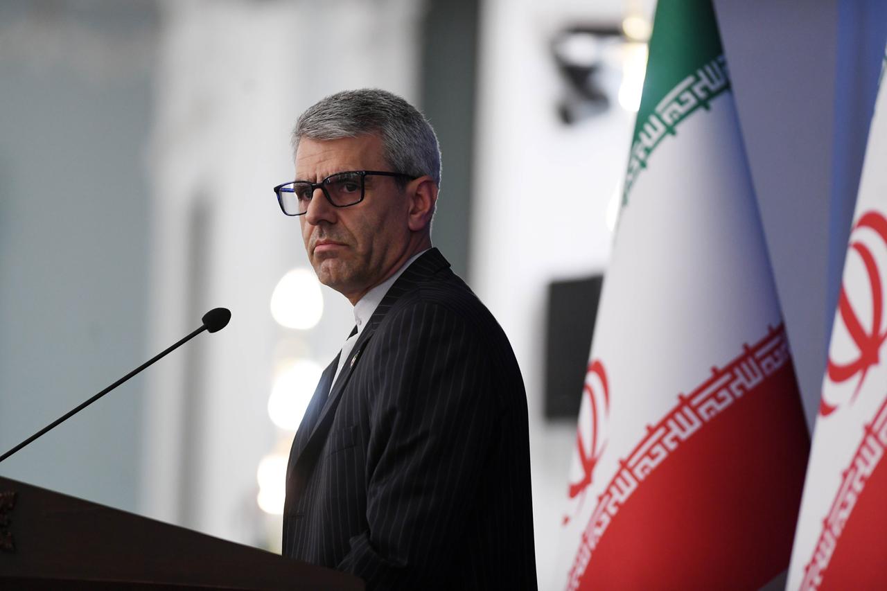 Ismail Baghai, Sprecher des iranischen Außenministeriums, schaut ernst. Neben ihm sind zwei große iranische Flaggen. Ismail Baghai, Sprecher des iranischen Außenministeriums, schaut ernst. Neben ihm sind zwei große iranische Flaggen.