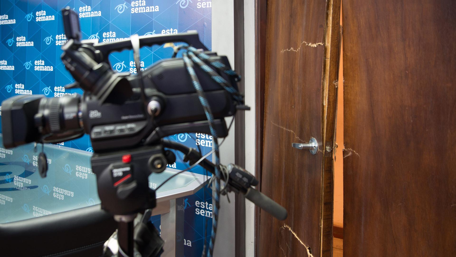 Kaputte Tür eines Büros von "Esta Noche", im Vordergrund steht eine Fernsehkamera