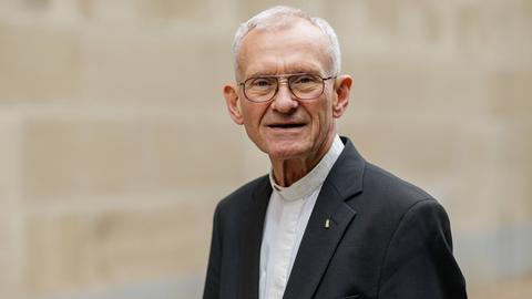 Franz Meurer lächelt in die Kamera. Er trägt eine Brille mit dünnem Rand und einen dunklen Anzug. Franz Meurer lächelt in die Kamera. Er trägt eine Brille mit dünnem Rand und einen dunklen Anzug.