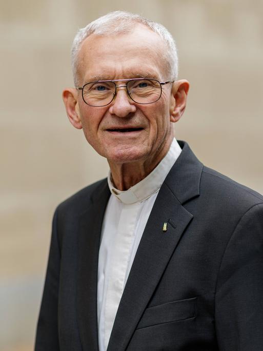 Franz Meurer lächelt in die Kamera. Er trägt eine Brille mit dünnem Rand und einen dunklen Anzug. Franz Meurer lächelt in die Kamera. Er trägt eine Brille mit dünnem Rand und einen dunklen Anzug.
