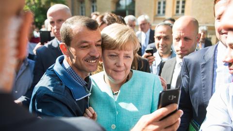 Angela Merkel lässt sich am 10.09.2015 in Berlin-Spandau für ein Selfie zusammen mit einem Flüchtling fotografieren. 