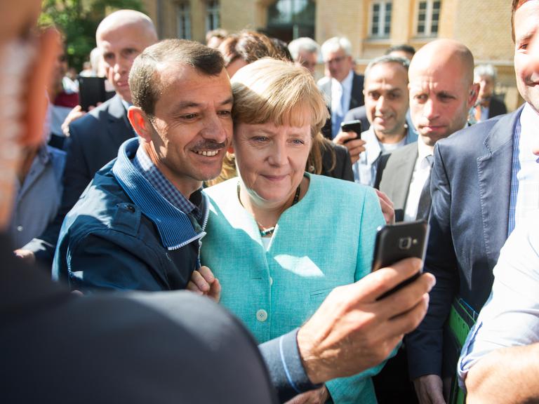 Angela Merkel lässt sich am 10.09.2015 in Berlin-Spandau für ein Selfie zusammen mit einem Flüchtling fotografieren. 