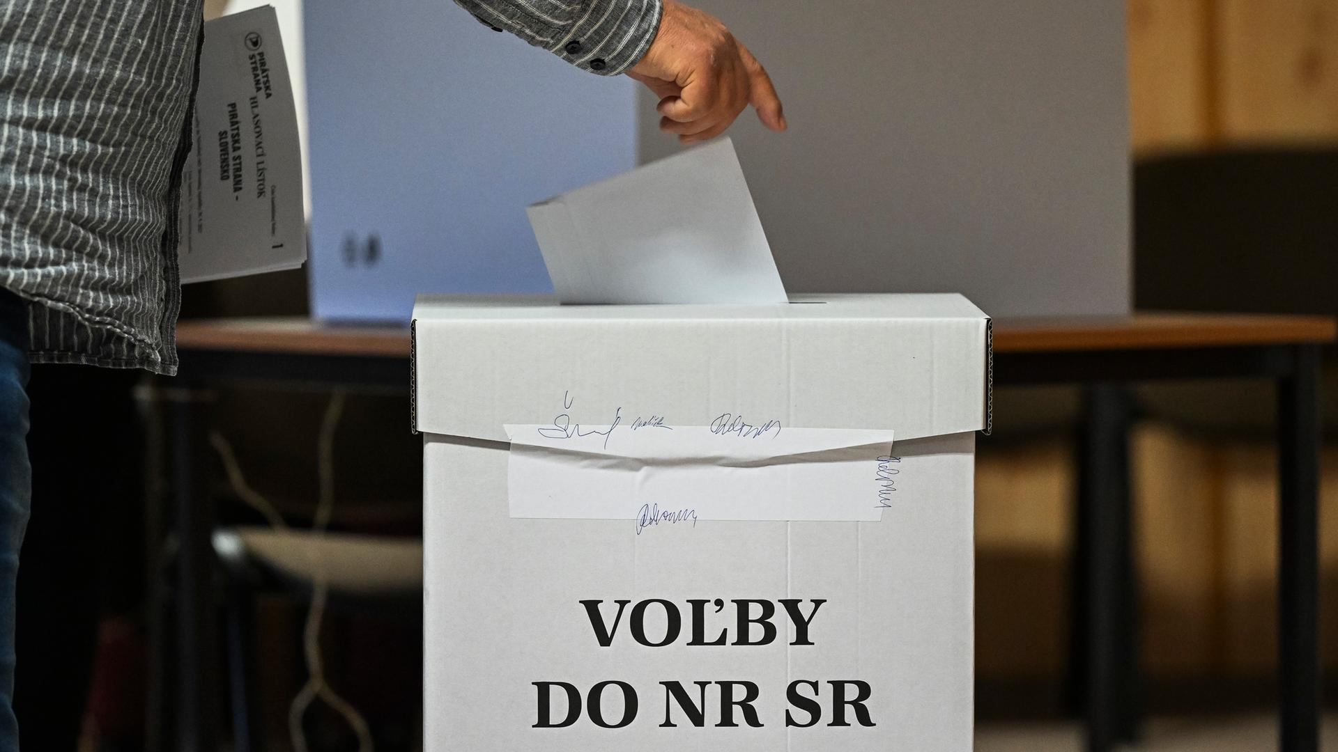 In Bratislava steckt ein Mann seinen Stimmzettel in eine Wahlurne.