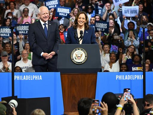 Kamala Harris steht mit Tim Walz an einem Rednerpult bei einer Wahlkampfveranstaltung in Philadelphia.