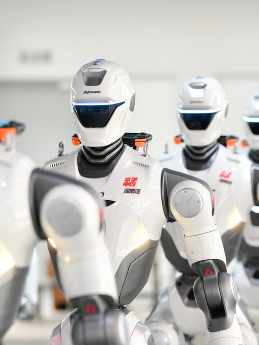 Mehrere humanoide Roboter der chinesischen Firma EngineAI stehen in einer Reihe.