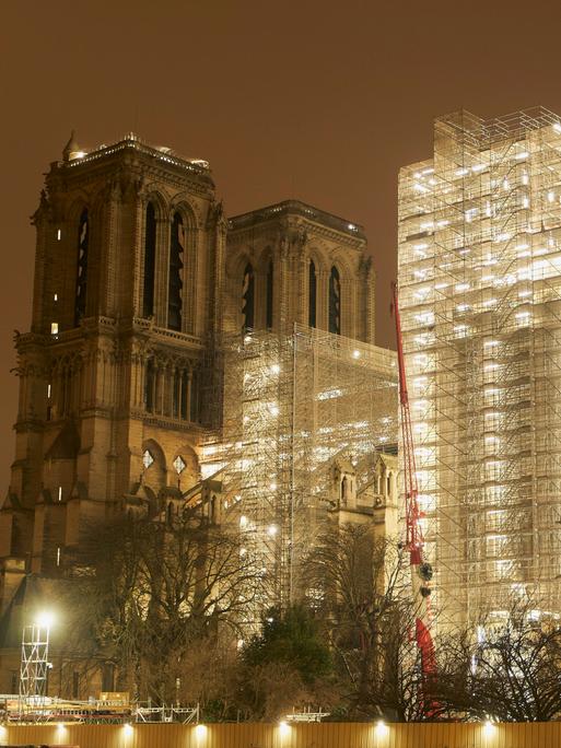 Das Gerüst an der Kathedrale Notre Dame in Paris ist hell beleuchtet.