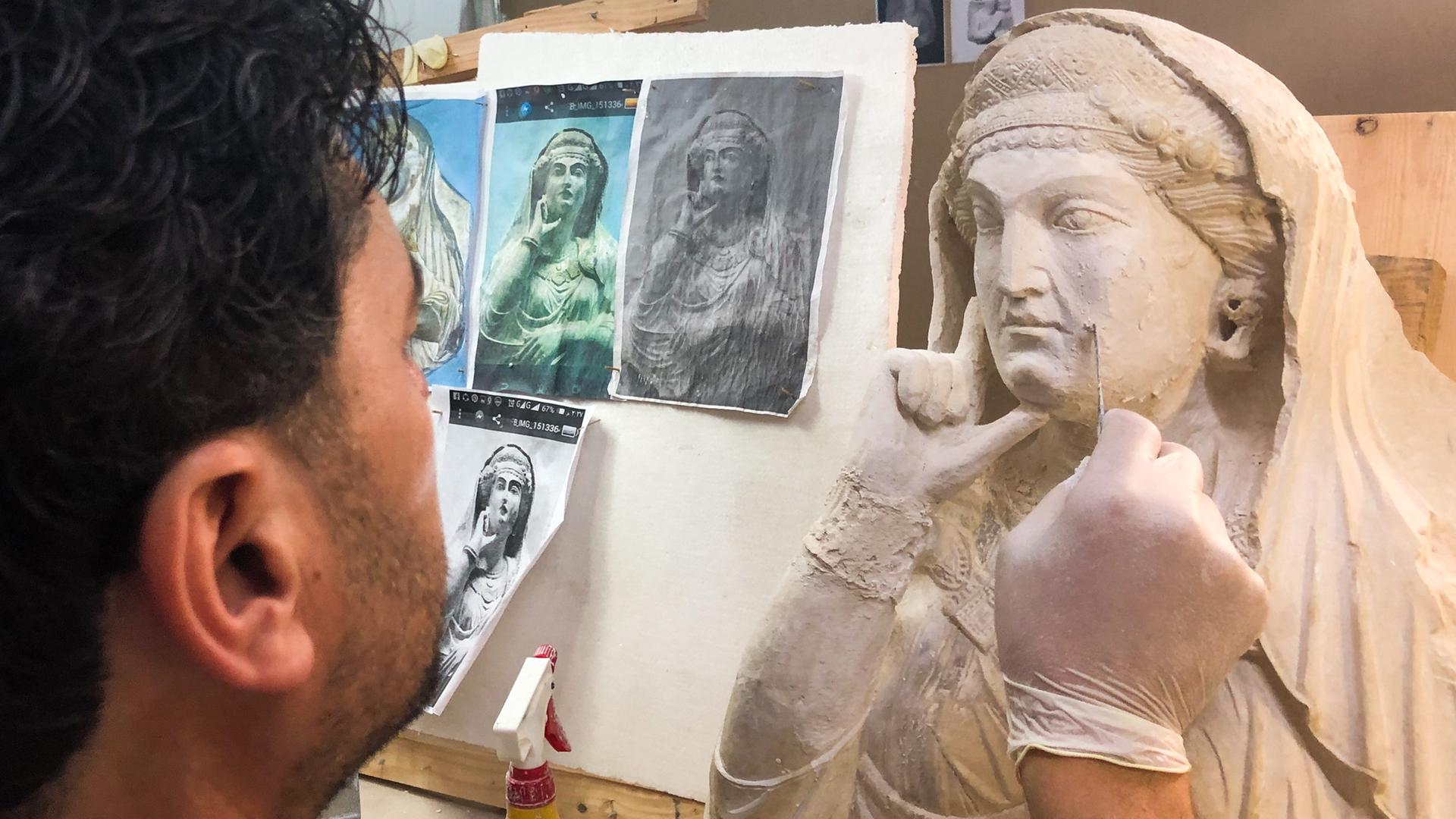 Ein Kunstrestaurator arbeitet an einem alten Basrelief aus Palmyra, das von Mitgliedern des IS zerstört wurde.