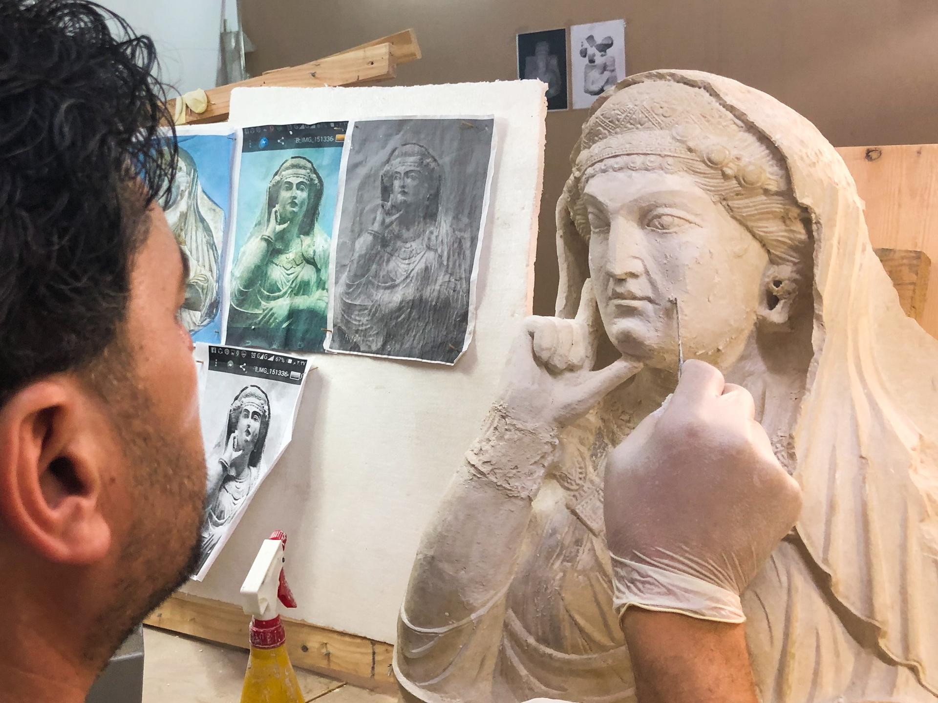 Ein Kunstrestaurator arbeitet an einem alten Basrelief aus Palmyra, das von Mitgliedern des IS zerstört wurde.