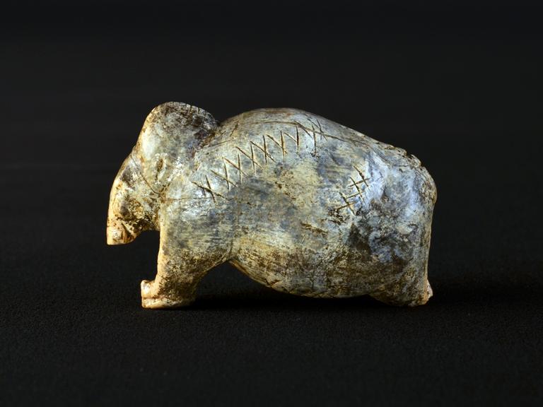 Die Mammut-Figurine aus der Vogelherd-Höhle ist etwa 40.000 Jahre alt und trägt auf ihrer Oberfläche mehrere Reihen von Kreuzen und Punkten.