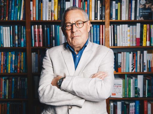 Der Autor Karl Schlögel posiert vor Bücherregalen in einer Buchhandlung am Bayrischen Platz in Berlin.