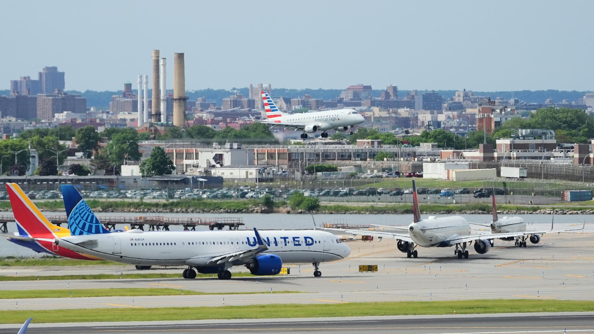 Das Foto zeigt einen Blick auf den Flughafen LaGuardia in New York. Mehrere Flugzeuge stehen am Boden, eine Maschine befindet sich im Landeanflug.