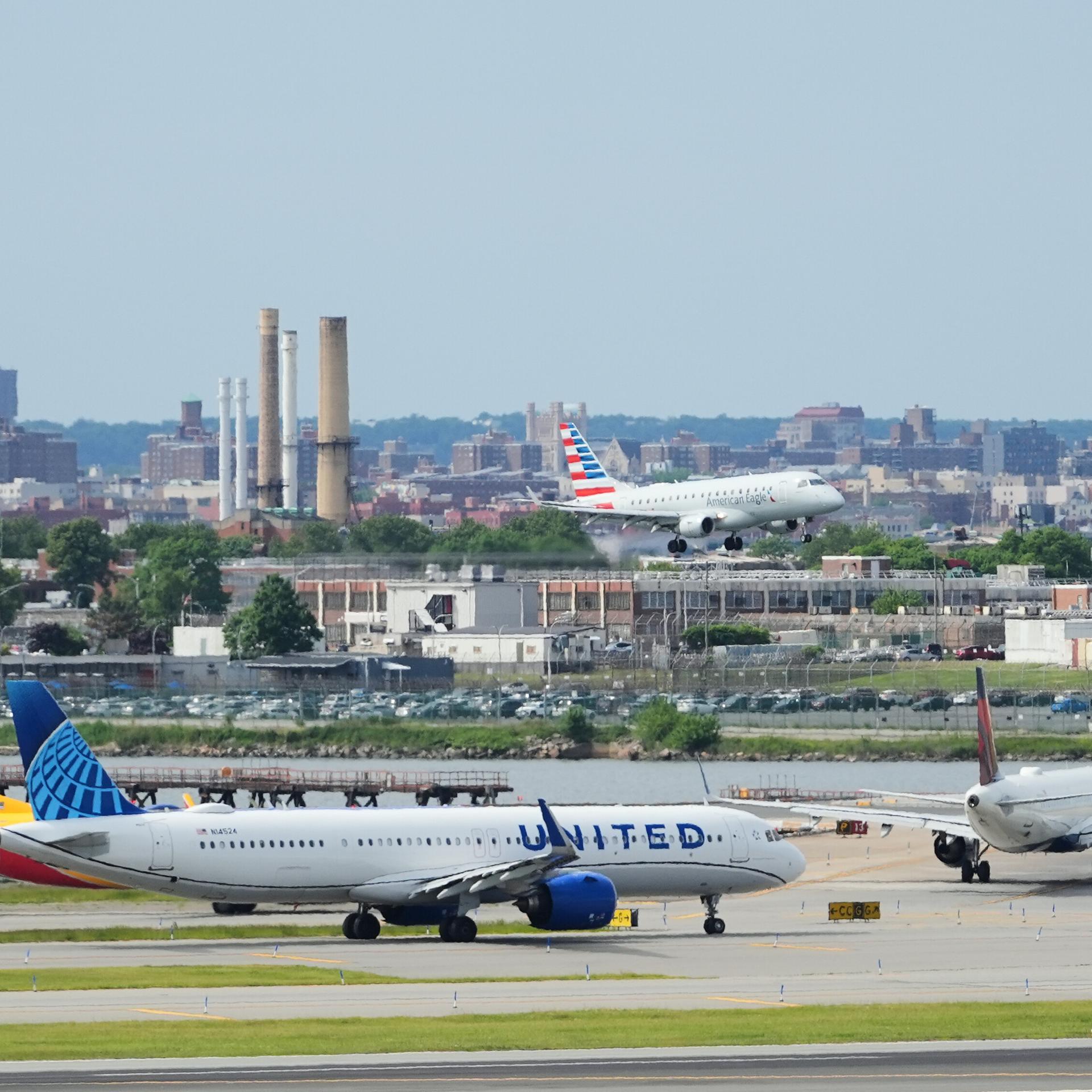 Das Foto zeigt einen Blick auf den Flughafen LaGuardia in New York. Mehrere Flugzeuge stehen am Boden, eine Maschine befindet sich im Landeanflug.