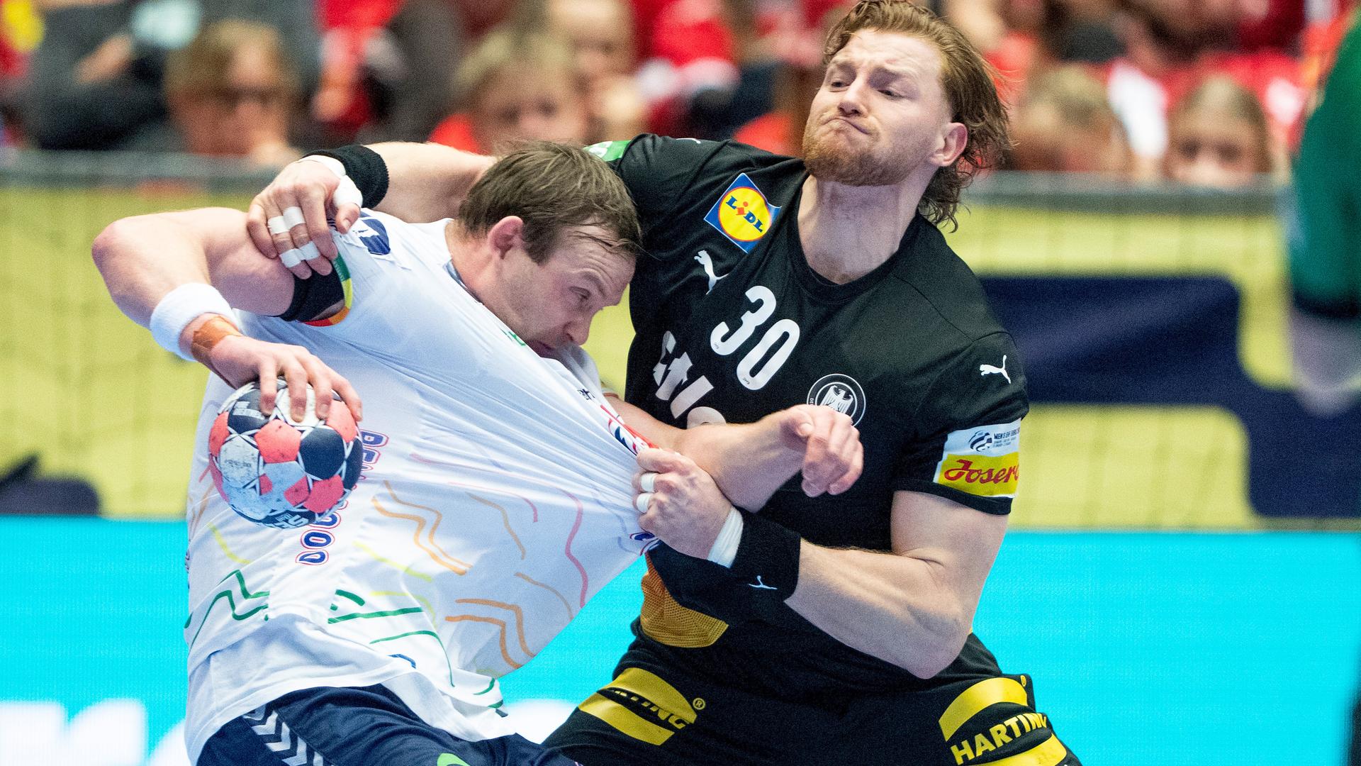 Der deutsche Spieler zieht dem norwegischen Spieler vorne am Trikot.