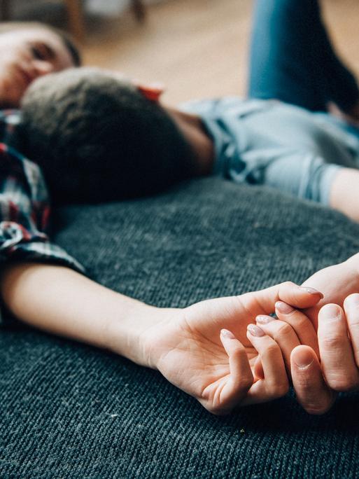 Eine Frau und ein Mann liegen auf dem Bett und schauen sich an