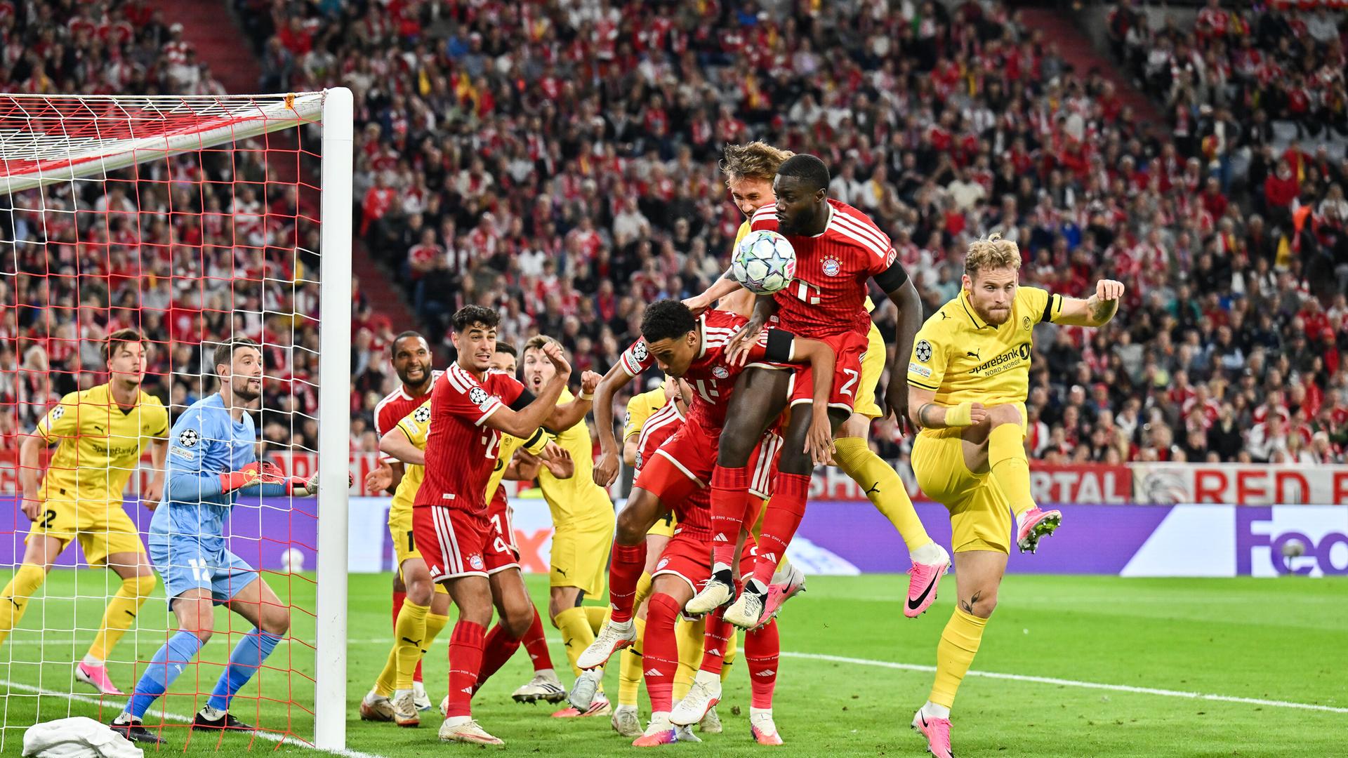 Fußballspieler springen nach einem Eckstoß in Richtung des Balls.